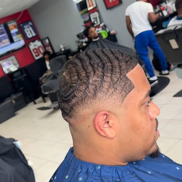 Fresh wave haircut with a clean fade and shaped hairline inside the barbershop